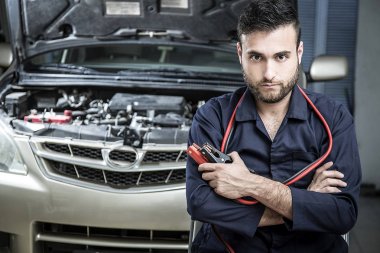 Garajdaki tamirci motoru tamir ediyor.