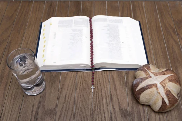 Bíblia, pão e água na mesa de madeira — Fotografia de Stock