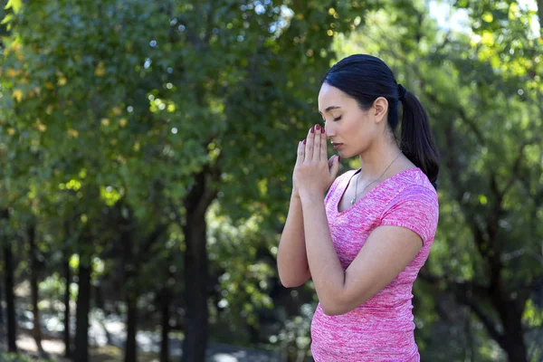 Mujer joven rezando antes de hacer ejercicio —  Fotos de Stock