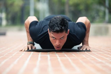 Genç adam dışarıda egzersiz yapıyor..