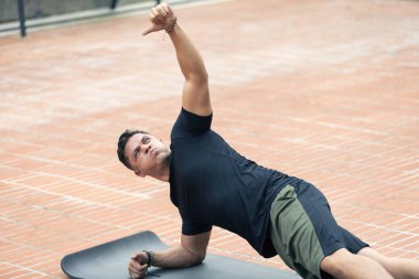 Genç adam dışarıda egzersiz yapıyor..