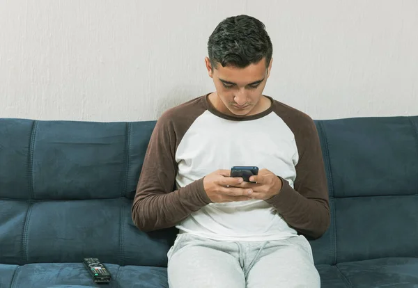 Kanepede Oturan Genç Adam Covid Salgını Sırasında Cep Telefonuyla Konsantre — Stok fotoğraf