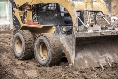 Sarı kazıcı makinesi inşaat sırasında çalışıyor..