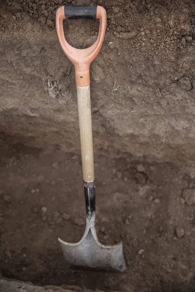 Shovel for the excavation thrown on sand in construction site. Work tools.