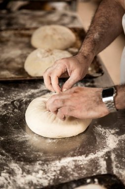 öğretmen baker masada ekmek üretiminde elinde