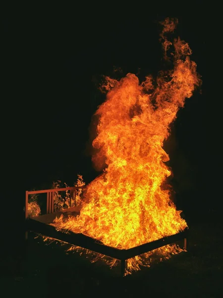 Mystic bed in fire in dark forest