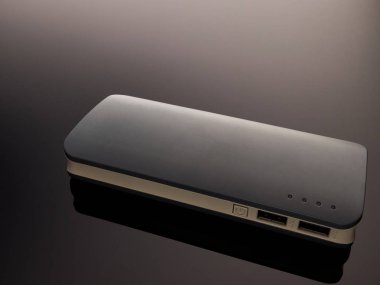 Gray mobile battery power bank on a gray gradient background