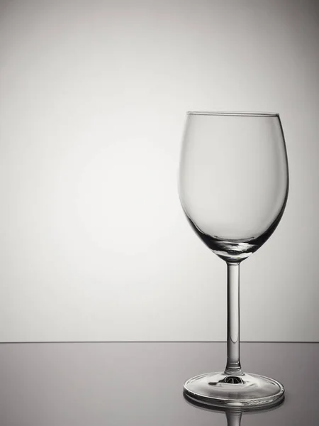 Splash of red wine in wine glass on white and gray gradient background. Isolated