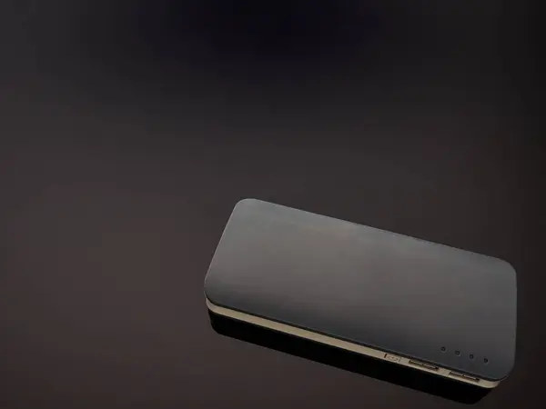 Gray mobile battery power bank on a gray gradient background