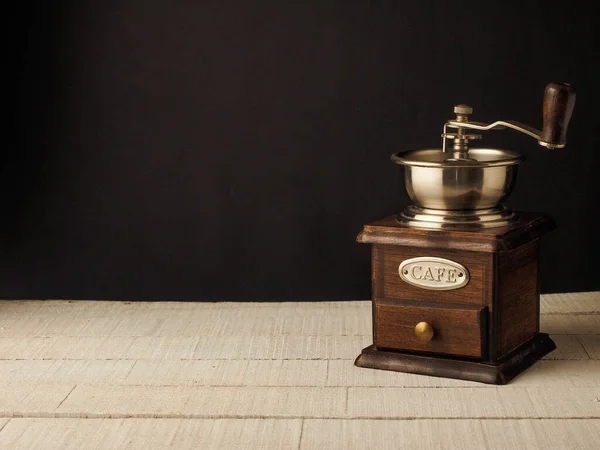 Koyu ve açık ahşap arka planda yakın plan kahve değirmeni..