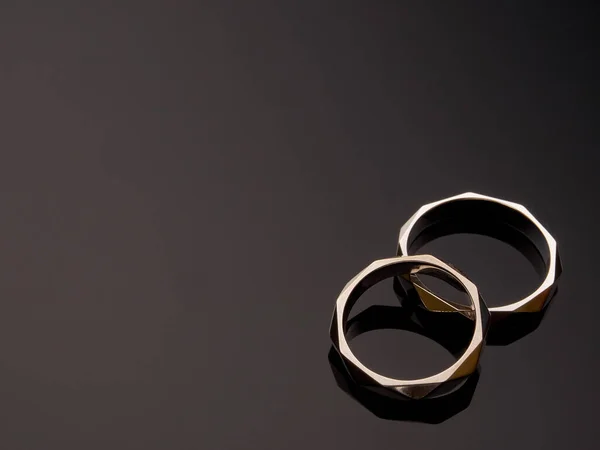 İki yönlü alyans, gri bir arkaplanda yakın plan beyaz altın halkalar.