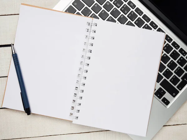 İş yeri - dizüstü bilgisayar, defter, kalem ve kalem beyaz ahşap bir masada uzaktan çalışma için. Ev ya da ofis için serbest bilgisayar. Kopyalama alanı olan arkaplan.