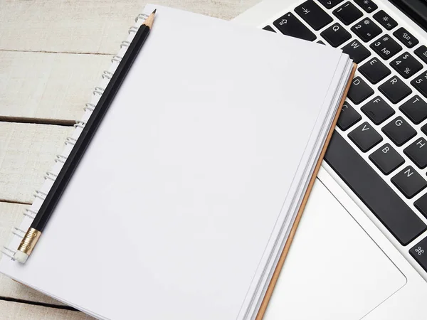 İş yeri - dizüstü bilgisayar, defter, kalem ve kalem beyaz ahşap bir masada uzaktan çalışma için. Ev ya da ofis için serbest bilgisayar. Kopyalama alanı olan arkaplan.