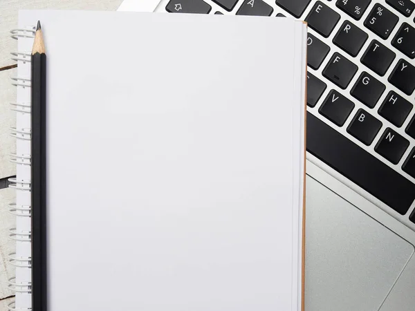 İş yeri - dizüstü bilgisayar, defter, kalem ve kalem beyaz ahşap bir masada uzaktan çalışma için. Ev ya da ofis için serbest bilgisayar. Kopyalama alanı olan arkaplan.