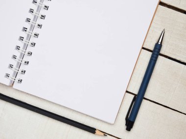 İşyeri - beyaz tahta bir masa üzerinde uzaktan kumanda için defter ve kalem. Ev ya da ofis için serbest bilgisayar. Kopyalama alanı olan arkaplan.