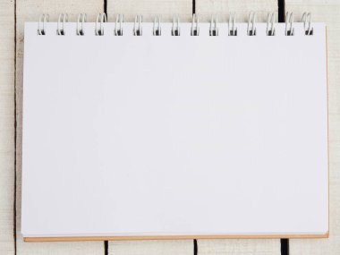 Üst Manzara. Çalışma alanı. Düz yatıyordu. Beyaz kırmızı bir tencerede yakın plan çekimde sulu. Hafif çarşaflı defter veya not defterini aç. Uzayı kopyala Mesaj için yer. Seçici odak