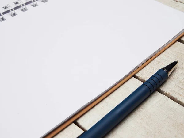 İşyeri - beyaz tahta bir masa üzerinde uzaktan kumanda için defter ve kalem. Ev ya da ofis için serbest bilgisayar. Kopyalama alanı olan arkaplan.