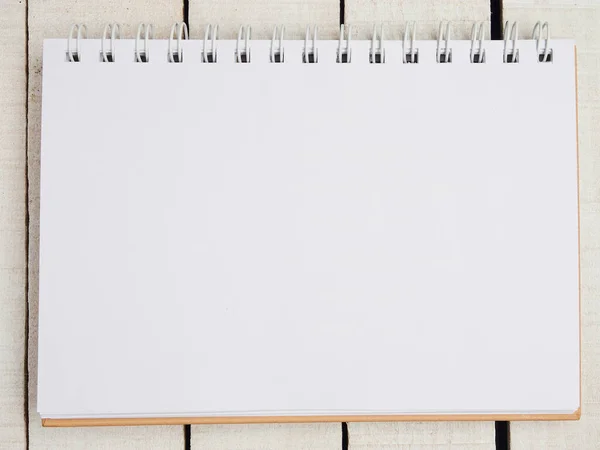 Üst Manzara. Çalışma alanı. Düz yatıyordu. Beyaz kırmızı bir tencerede yakın plan çekimde sulu. Hafif çarşaflı defter veya not defterini aç. Uzayı kopyala Mesaj için yer. Seçici odak