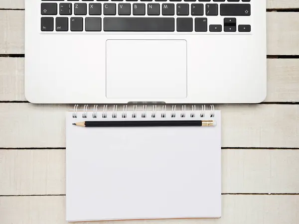 İşyeri - dizüstü bilgisayar, defter ve kalem beyaz ahşap bir masa üzerinde uzaktan çalışma için. Ev ya da ofis için serbest bilgisayar. Kopyalama alanı olan arkaplan.