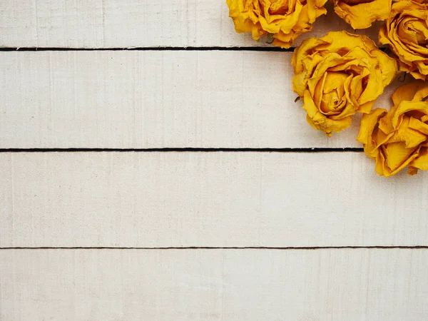 Beyaz ahşap arka planda kurumuş gül çiçekleri. Uzayı kopyala Çerçeve. Metin ve tasarım için yer. Tebrik kartı. Düz yerde, üst tarafta. Seçici odak.