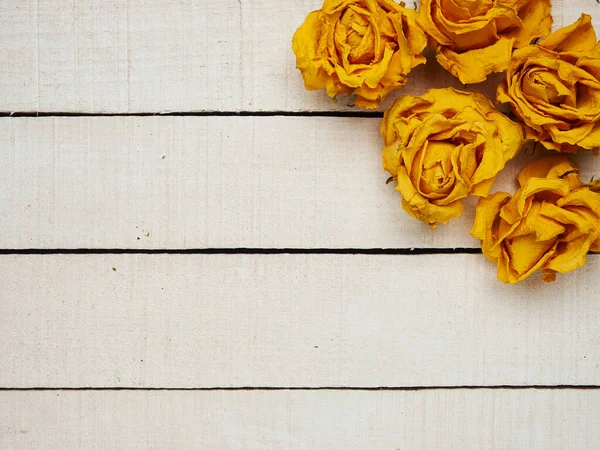 Beyaz ahşap arka planda kurumuş gül çiçekleri. Uzayı kopyala Çerçeve. Metin ve tasarım için yer. Tebrik kartı. Düz yerde, üst tarafta. Seçici odak.