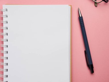 Ev yapımı uzaktan eğitim Coronavirus quarantin. Pembe arka planda kalem, defter ve gözlük..