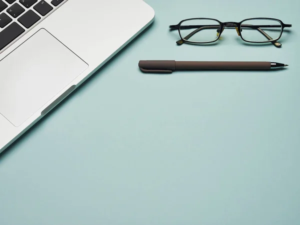 Merkez ofis geçmişi. Uzaktan çalışma ve eğitim. Coronavirus karantinası. Evden iş ve eğitim. Mavi arkaplanda dizüstü bilgisayar, kalem ve gözlük.