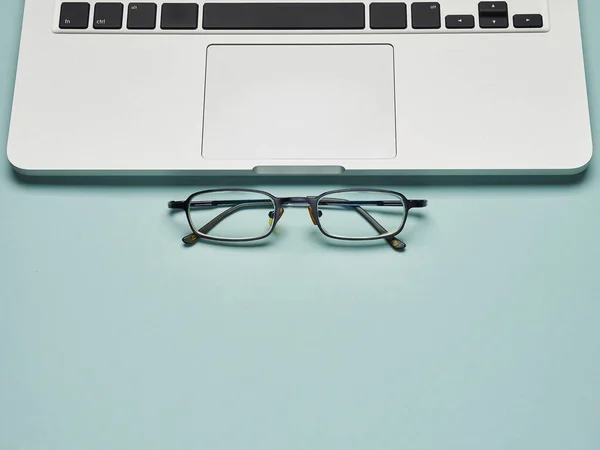 Merkez ofis geçmişi. Uzaktan çalışma ve eğitim. Coronavirus karantinası. Evden iş ve eğitim. Mavi arkaplanda dizüstü bilgisayar ve gözlük.