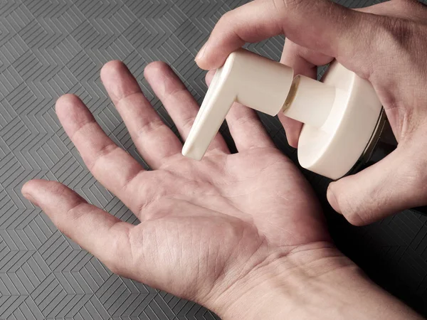 Metro istasyonunda el temizleme jeli kullanan bir erkek. Pandemik koruma için sağlık farkındalığı. Sağlık hizmeti kavramı