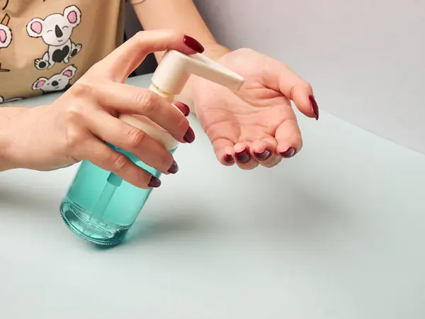 Kadın ellerini antiseptik sprey kutusuyla dezenfekte ediyor. Koronavirüsle mücadelede önlem. Seçili Odaklanma.