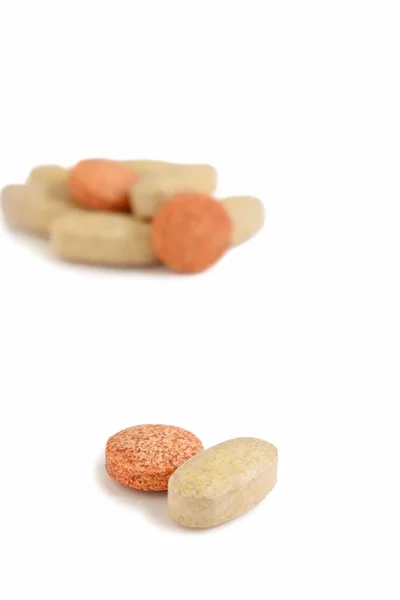 Comprimidos de vitamina em fundo branco — Fotografia de Stock