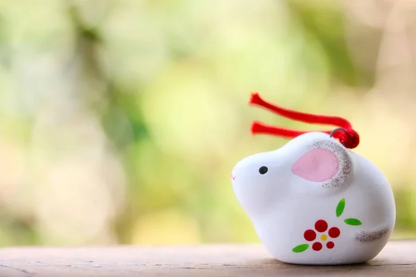 A cute looking Japanese good luck charm rat for celebrating year of the rat on green background.