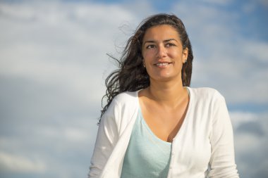 Çekici genç kadın kopya alanı ile gökyüzü arka plan üzerinde gülümseyen
