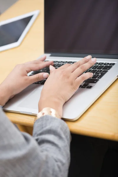 Focus on hands of woman typing on laptop computer Royalty Free Stock Images