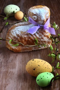 Easter lamb cake with purple ribbon, easter eggs and willow sticks on wooden table / desk