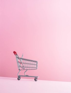 Pembe bir arka plan üzerinde alışveriş sepeti