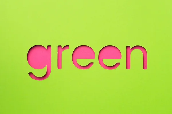 Palabra verde hecha de papel sobre fondo rosa — Foto de Stock