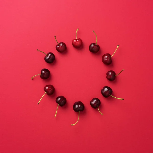 Cherries organized in circle over red background