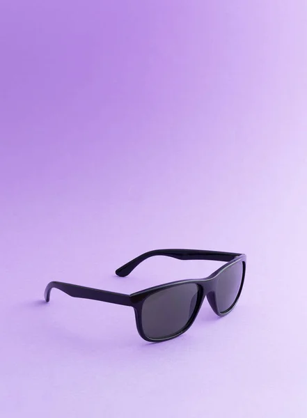 Zwarte zonnebril op paarse achtergrond — Stockfoto