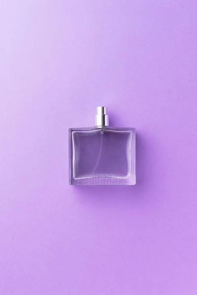 Frasco de perfume sobre fondo púrpura — Foto de Stock