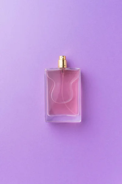 Frasco de perfume sobre fondo púrpura — Foto de Stock