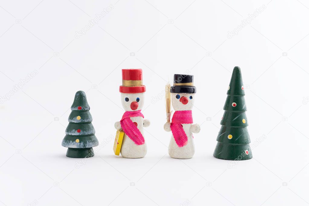 Two snowmans and two Christmas trees over white background