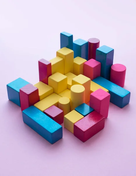 Colorful color block cubes organized over pink background