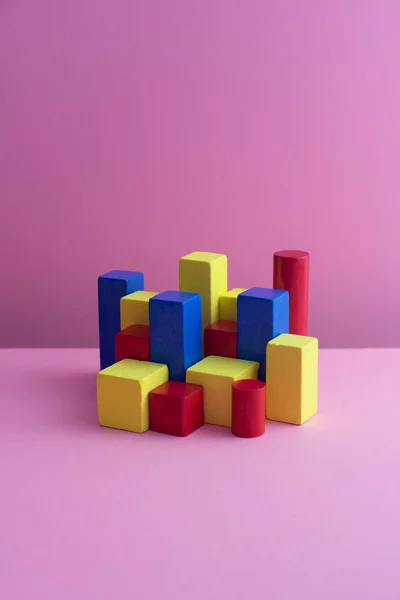 Colorful color block cubes organized over pink background