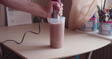 Evde protein içeceği yapan bir adam.