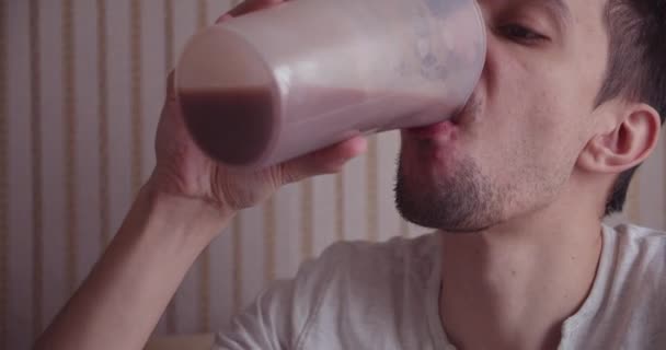 Joven bebiendo una bebida saludable de batido o una proteína, él tan sorprendido — Vídeos de Stock