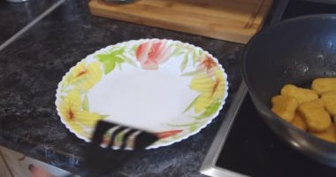 Kızarmış tavuk nugget eti, kızgın bir tavada kızartılıyor.