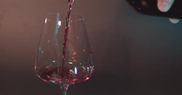 병에 담긴 붉은 포도주를 유리잔에 붓는 모습 — 비디오