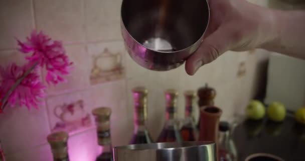 Giet een cocktail in een shaker en raakt de shaker — Stockvideo