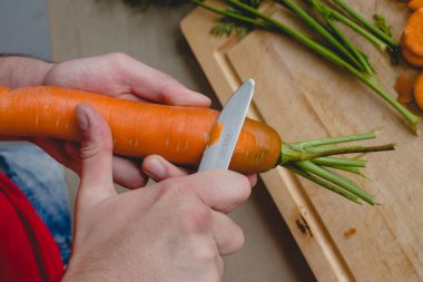 Yemek, doğal. Adam havuç kesiyor.